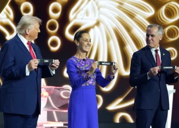 WASHINGTON, DC - DECEMBER 05: U.S. President Donald Trump, Claudia Sheinbaum, President of Mexico, and Mark Carney, Prime Minister of Canada, show the draw on stage during the FIFA World Cup 2026 Official Draw at John F. Kennedy Center for the Performing Arts on December 05, 2025 in Washington, DC. (Photo by Stephanie Scarbrough - Pool/Getty Images)