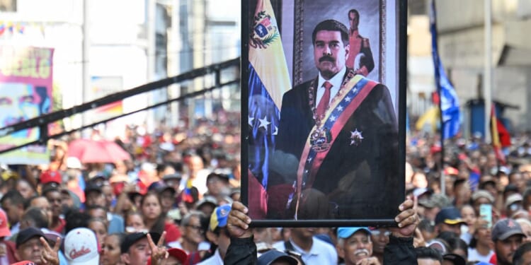 Supporters of ousted Venezuelan President Nicolas Maduro carry his portrait in a rally in Caracas on Jan. 5, 2026.