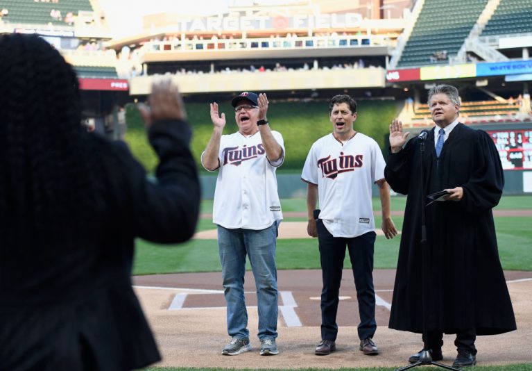 MINNEAPOLIS, MINNESOTA - SEPTEMBER 17: Minnesota Governor Tim Walz (left) and Minneapolis Mayor Jacob Frey celebrate as a judge swears in a new group of American citizens before the game between the Minnesota Twins and the Chicago White Sox at Target Field on September 17, 2019 in Minneapolis, Minnesota. (Photo by Hannah Foslien/Getty Images)