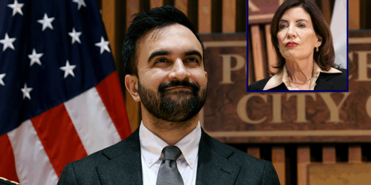 (Background) New York City Mayor Zohran Mamdani attends a news conference at the headquarters of the NYPD on January 06, 2026 in New York City. Mamdani, who was joined by New York Gov. Kathy Hochul and Police Commissioner Jessica Tisch, discussed crime statistics and safety, including a historic drop in shootings in New York City last year. (Photo by Spencer Platt/Getty Images) / (R) New York Governor Kathy Hochul looks on during a public safety-related announcement at the headquarters of the New York City Police Department (NYPD) in New York on January 6, 2026. (Photo by CHARLY TRIBALLEAU / AFP via Getty Images)