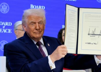 President Donald Trump holds up his signature on the founding charter during a signing ceremony for the “Board of Peace” at the World Economic Forum on Jan. 22, 2026, in Davos, Switzerland.