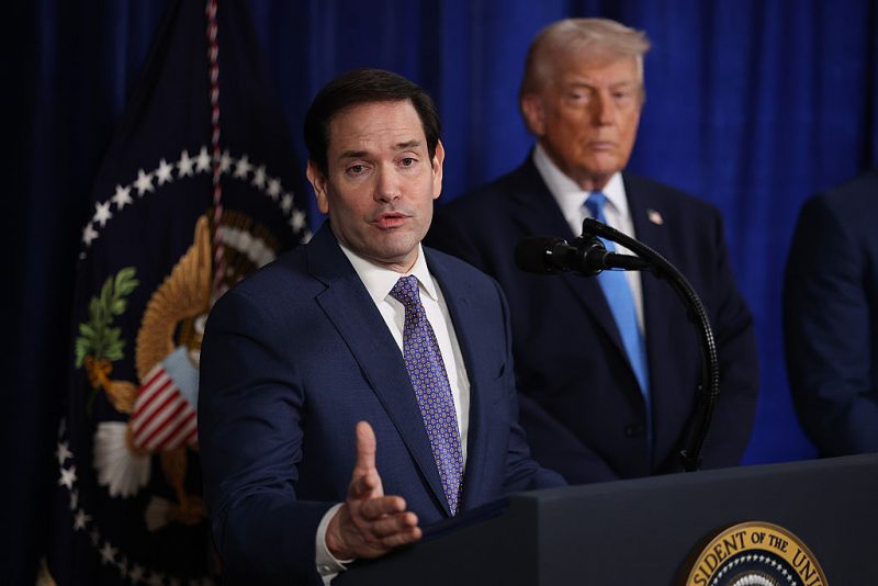 PALM BEACH, FLORIDA - JANUARY 03: U.S. Secretary of State Marco Rubio speaks during a press conference as U.S. President Donald Trump listens at Mar-a-Lago club on January 03, 2026, in Palm Beach, Florida. During the event, President Trump confirmed that the U.S. military carried out a large-scale strike in Caracas overnight, resulting in the capture of Venezuelan leader Nicolas Maduro and his wife, Cilia Flores. (Photo by Joe Raedle/Getty Images)