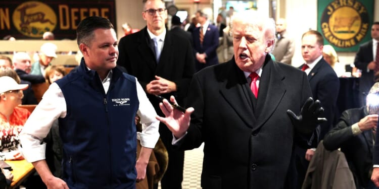 President Donald Trump speaks to guests alongside GOP Rep. Zach Nunn of Iowa, left, as he visits the Machine Shed restaurant Tuesday in Urbandale, Iowa.