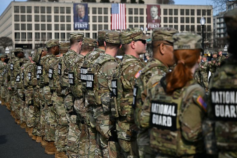 Members of the National Guard look on during a procession for Metropolitan Police Department (MPD) officer Terry Bennett, who passed away on January 7 after being struck on a highway while helping a stranded driver on December 23, 2025, in Washington, DC, on January 8, 2026. (Photo by Brendan SMIALOWSKI / AFP via Getty Images)