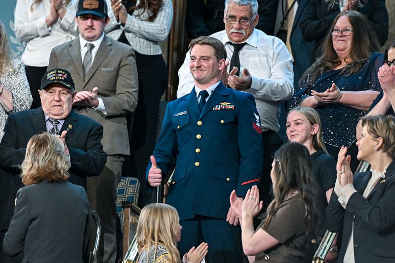 WASHINGTON, DC - FEBRUARY 24: U.S. Coast Guard Petty Officer Scott Ruskan and Milly Cate, a camper who was rescued by Ruskan during the flooding at Camp Mystic, attend President Donald Trump's State of the Union address during a joint session of Congress at the Capitol on February 24, 2026 in Washington, DC. Trump delivered his address days after the Supreme Court struck down the administration's tariff strategy, and amid a U.S. military buildup in the Persian Gulf threatening Iran. (Photo by Kenny Holston-Pool/Getty Images)