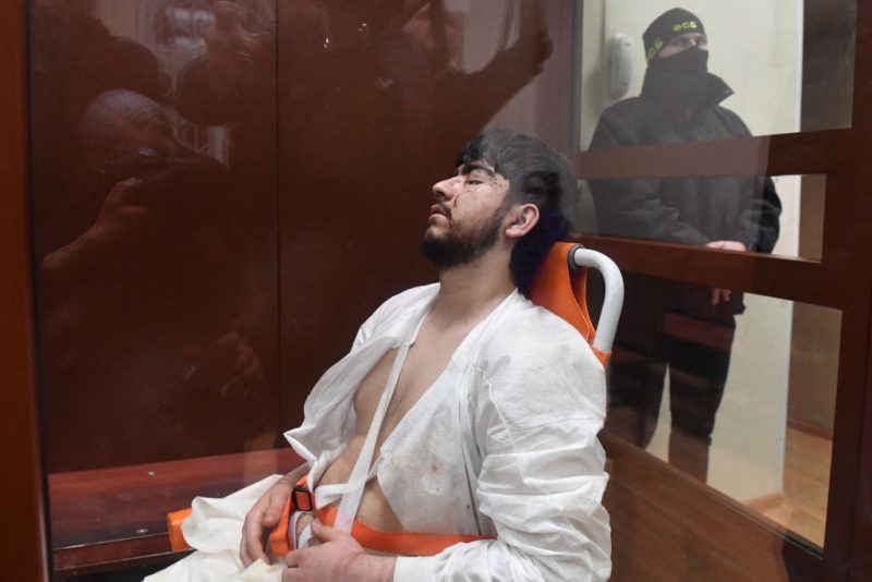 A man suspected of taking part in the attack of a concert hall that killed 137 people, the deadliest attack in Europe to have been claimed by the Islamic State jihadist group, sits inside the defendant cage as he waits for his pre-trial detention hearing at the Basmanny District Court in Moscow on March 25, 2024. At least 137 people, including three children, were killed when camouflaged gunmen stormed the Crocus City Hall, in Moscow's northern suburb of Krasnogorsk, and then set fire to the building on March 22 evening. (Photo by Olga MALTSEVA / AFP) (Photo by OLGA MALTSEVA/AFP via Getty Images)