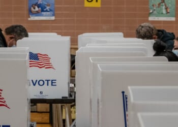 Masked voters cast their ballots at a polling place in the pandemic-era 2020 presidential election.