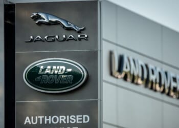 A Jaguar logo sits on a sign in the middle of the day outside a car dealership in Taunton, England on May 8, 2025.