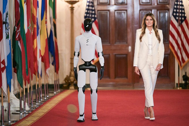 US First Lady Melania Trump walks with a humanoid robot as she arrives for the Fostering the Future Together Global Coalition Summit in the East Room of the White House in Washington, DC, on March 25, 2026. (Photo by Oliver Contreras / AFP via Getty Images)