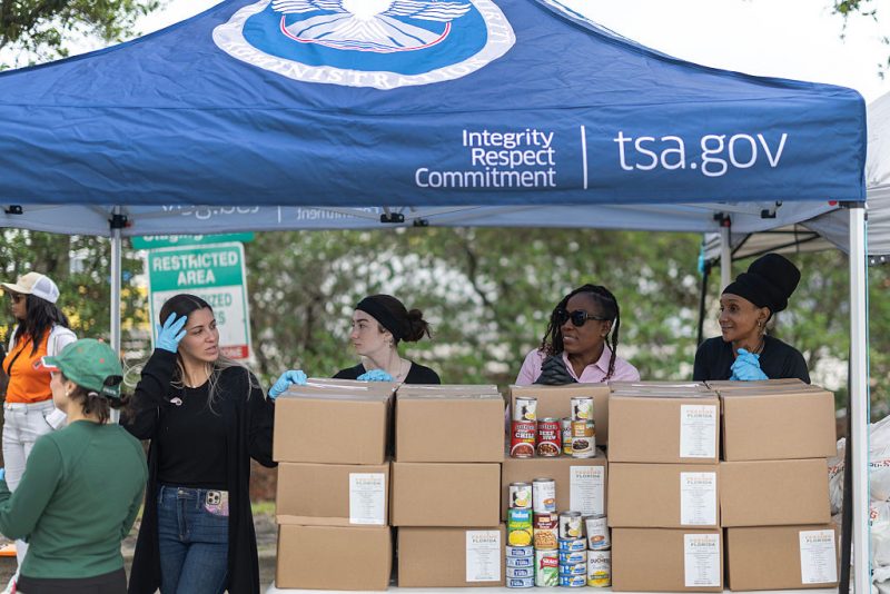MIAMI, FLORIDA - MARCH 17: Feeding South Florida volunteers wait to give out food items to government employees who have been impacted by the partial government shutdown on March 17, 2026 in Miami, Florida. The food distribution was held at the Miami International Airport employee parking lot. Impacted government employees and contractors received fresh produce and shelf-stable items with a valid TSA identification. Some TSA officers have been working without pay since federal funding for DHS lapsed on Feb. 14. (Photo by Joe Raedle/Getty Images)