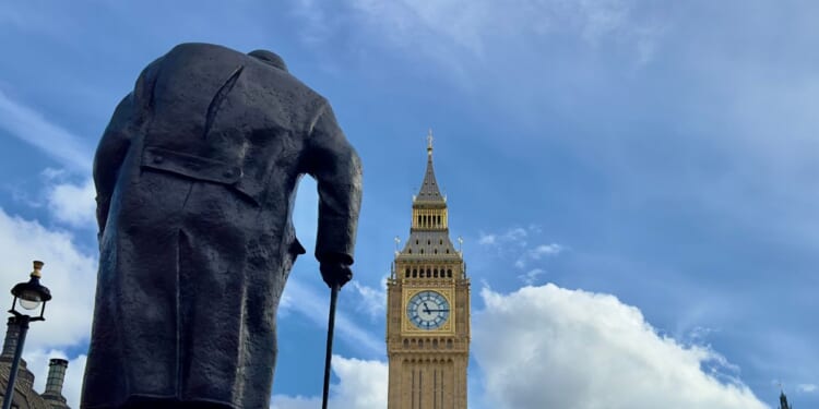 Big Ben and the Houses of Parliament with a statue of Sir Winston Churchill seen from behind in the foreground on March 4, 2024, in London, England.