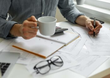 Person with tax documents and calculator