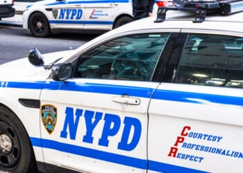 NYPD police cars and a police van on both sides of the street in Manhattan, New York City.