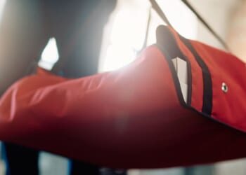 A close up of a delivery courier carrying pizza in a thermal bag.