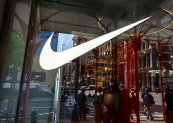 NEW YORK, NEW YORK - APRIL 24: The iconic Nike swoosh design is displayed in a window of the athletic company