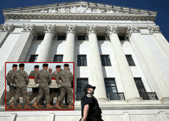 (Background) A Supreme Court Police Officer walks along the back side of the US Supreme Court as President Donald Trump attends oral arguments, in Washington, DC on April 1, 2026. President Donald Trump will watch the US Supreme Court hear a landmark case weighing the constitutionality of his contentious bid to end birthright citizenship, an extraordinary and possibly unprecedented move for the nation