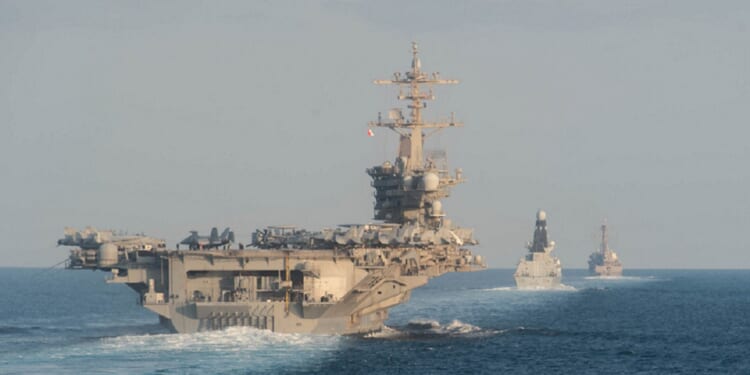 The USS Abraham Lincoln is pictured in a file photo from the Strait of Hormuz in November 21019. It is accompanied by the Royal Navy air defense destroyer HMS Defender and the guided-missile destroyer USS Farragut.