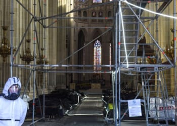 A clearance worker wearing a protective suit stands at the entrance of Nantes Cathedral, severely damaged by a fire in July, in Nantes, western France, on Feb. 26, 2021.