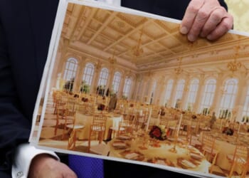 President Trump sits in the Oval Office and shows plans for the White House ballroom on October 22, 2025.